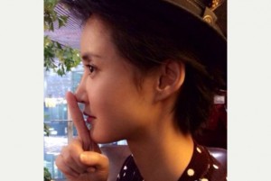 Asian woman puts finger from chin to tip of nose.