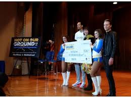 Warriors player and cheerleaders present giant check.