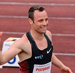 Pistorius in track suit waving to crowds.