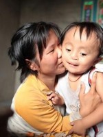 Mother holding 4 yr old Vietnamese boy w cleft