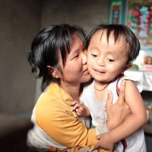 Mother holding 4 yr old Vietnamese boy w cleft