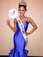 Woman in gown and crown holds sign for Smile Train