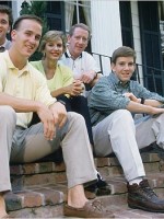 Cleft palate P Manning (l) sitting on steps with family or origin, incl QB dad (ctr) & QB bro (r).