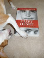 Small dog named Monte about to chew on book abt cleft lip.