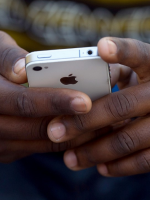 Cyberbully victim portryed by black hands holding electronic gadget, Caribbean360