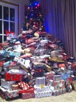 Xmas tree swamped by too many gifts showing Materialism, Consumerism.Bullying & Overindulgence & Bullying.