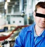 Car repair fraud. Mechanic in blue coveralls.